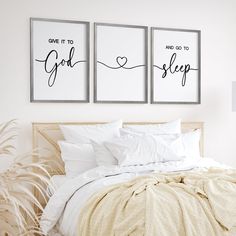 a bed with white sheets and two framed pictures on the wall next to each other