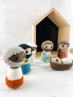 crocheted nativity figurines are displayed in front of a small house