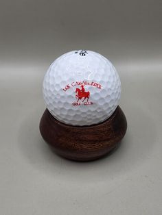 a white golf ball sitting on top of a wooden stand