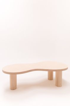 an oval wooden table sitting on top of a white floor