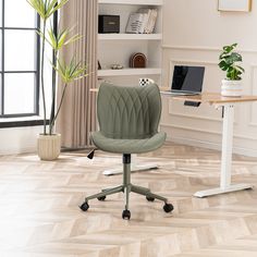 a desk with a laptop on it and a chair next to it in front of a window