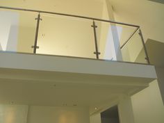 a balcony with glass railings and white walls