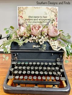 an old fashioned typewriter with flowers on it