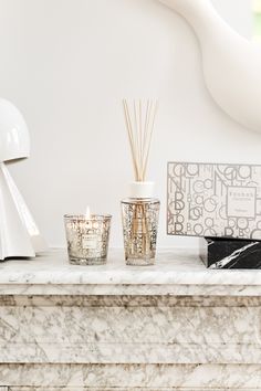 the candles are sitting on top of the mantle next to the candle holder and other items