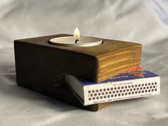 a small candle sitting on top of a book next to it's cover,