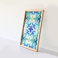 a wooden frame with a cross stitch pattern on it