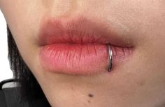 a woman's lip with a ring on her left side and the tip of her nose