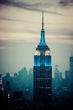 the empire building lit up in blue and white