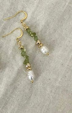 Statement Peridot & Pearl Cascade Dangle Earrings  Designed to make a statement, these bold dangle earrings bring elegance to any outfit. Handmade with genuine peridot stones, freshwater pearls, and gold-plated accents, they're perfect for those moments when you want to feel extra special. Whether it's a wedding, a holiday party, or a romantic evening out, these earrings will turn heads and add a touch of sophistication to your look.                               From Our Timeless Peridot & Pearl Collection                                                  Crystal Cascade Earrings * Product   Detail * - Crystal quartz, green glass bead, freshwater pearl - Clasp: Fishhooks - Gold-plated  - Style: Vintage-inspired, holiday-ready elegance - Tarnish - Resistance - Handmade and made to order - L Gold Homemade Jewelry, Homemade Dangle Earrings, Homemade Gold Earrings, Earring With Beads, Beads Earrings Design, 2025 Earring Trends, Pearl Earring Ideas, Beaded Pearl Earrings, Vintage Beaded Jewelry