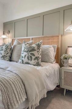 a bed with white linens and pillows in a bedroom next to two lamps on either side of the bed