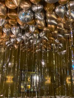 many shiny balloons are hanging from the ceiling