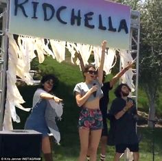 three people standing under a sign that says ridchella on the side of it