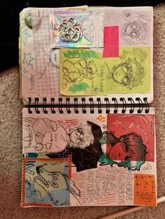 an open notebook with drawings and stickers on top of it, sitting on the floor