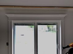 an open window in a room with white walls and wood trim on the windowsill