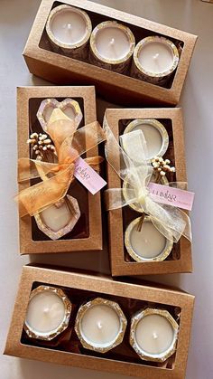 three boxed candles are sitting on a table