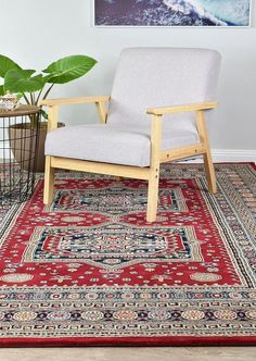 a chair sitting on top of a rug next to a potted plant