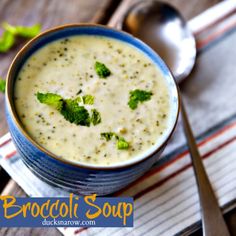 broccoli soup in a blue and white bowl on a striped napkin next to a spoon