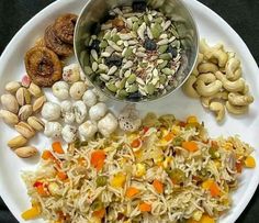 a white plate topped with different types of food next to nuts and other foodstuffs