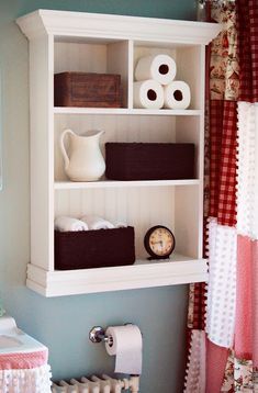 a bathroom with toilet paper and towels on the shelves