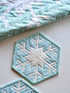 two blue and white quilts laying next to each other on top of a table