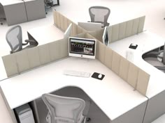 an office cubicle with two computer screens and chairs