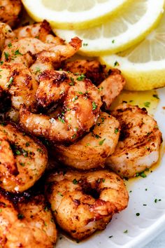 grilled shrimp on a plate with lemon wedges