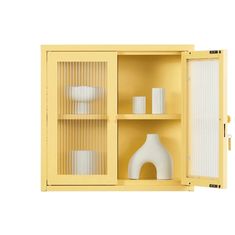 a yellow cabinet with white vases and other items in front of it on a white background