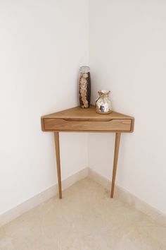 a wooden table with two vases on it and a white wall in the background