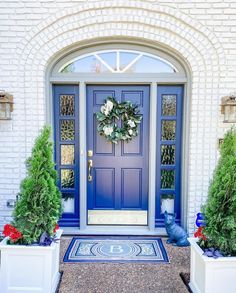 a blue front door with two white planters