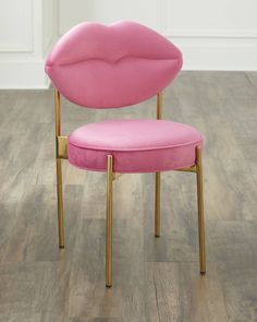 a pink chair sitting on top of a wooden floor