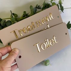 two metal tags that say treatment and toilet