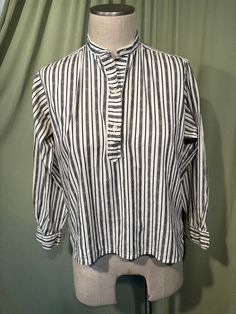 This is an adorable vintage blouse from the 60s or so. Labeled Gordon Peters, Man Tailored. No size tag. The bust measures 40" with measurements below. Made of a black & white cotton blend in a vertical stripe pattern. The pullover blouse closes down the front bodice with plastic buttons. The blouse has long sleeves with button cuffs. Hem is straight with small vents on the side seams. The collar has two buttonholes at the top for a button link or other pin type closure, which is not included. The inside of the collar has 3 small buttons, most likely had some sort of removable tie at some point in time.    The blouse is in very good condition!  No damage. No stains or soil. Super cute!  If you have never worn vintage before, please measure yourself!! Vintage sizes run smaller than today's Classic Top With Striped Collar For Daywear, Cotton Gingham Top For Daywear, Collared Plaid Tops For Daywear, Classic Striped Tops For Daywear, Plaid Collared Top For Daywear, Classic Gingham Cotton Top, Striped Collared Blouse With Placket, Retro Collared Top For Work, Gingham Button-up Tops For Daywear