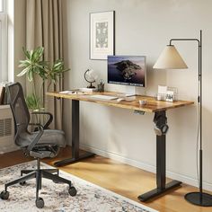 a desk with a computer on it and a lamp next to it in a room