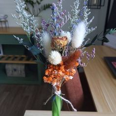 a vase filled with flowers on top of a wooden table