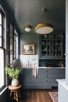 a kitchen with gray cabinets and wood floors