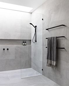 a bathroom with a glass shower door and towel rack on the wall next to it