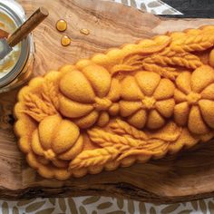 a wooden board topped with lots of food next to a jar of peanut butter on top of it