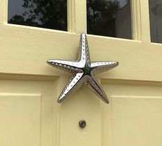 a metal star on the side of a yellow door