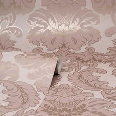 the wall paper is pink and gold with an intricate design on it's surface