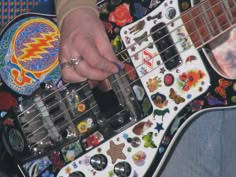 a person is playing an electric guitar decorated with stickers