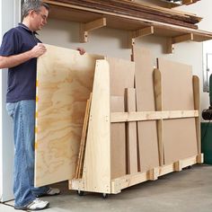 a man is standing next to some plywood