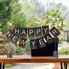 a happy new year banner on a table in front of some plants and trees,