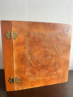 an old leather book with intricate carvings on the front and sides, sitting on a table