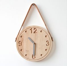 a wooden clock hanging from the side of a wall with numbers on it's face