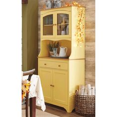 a yellow china cabinet with glass doors