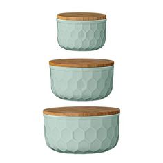 three ceramic bowls with wooden lids are stacked on top of each other