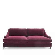 a red velvet couch against a white background with no one in the room looking at it