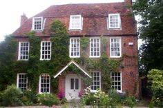 an old brick house with ivy growing all over it's sides and windows on the side