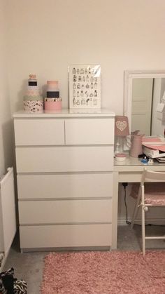 a white dresser sitting next to a pink rug