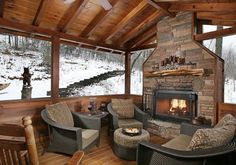 a living room filled with furniture and a fire place in the middle of a snow covered forest